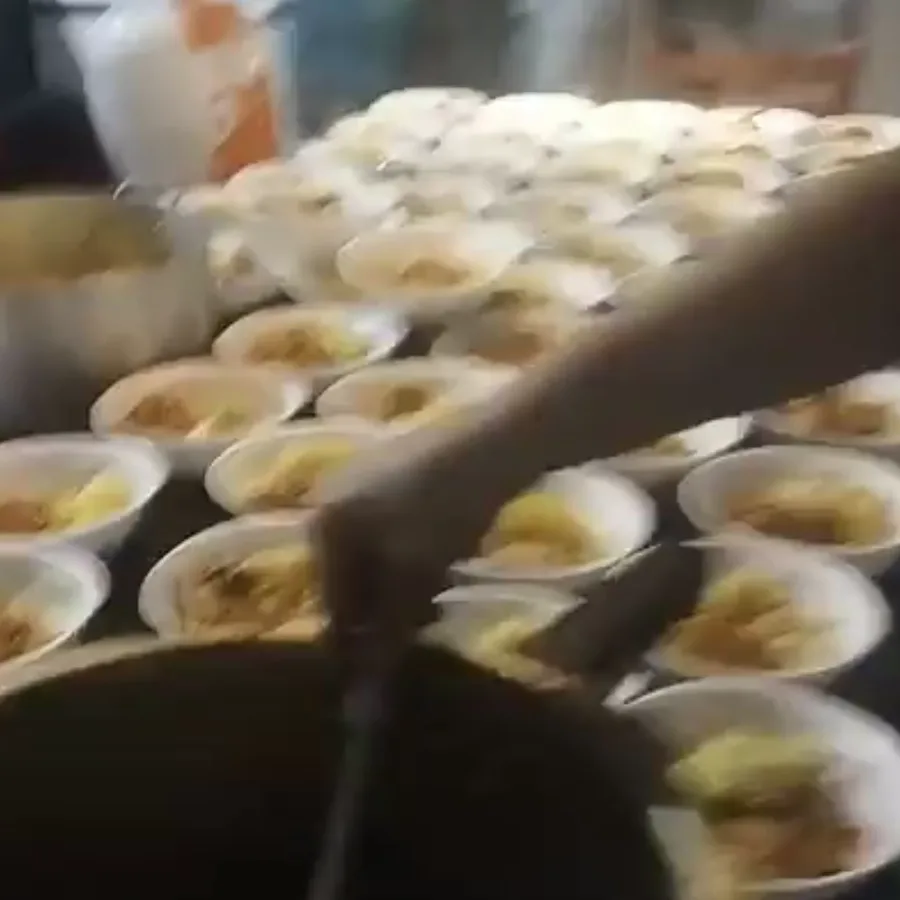 Cozinha do Cambuci Solidário com dezenas de marmitas sendo montadas